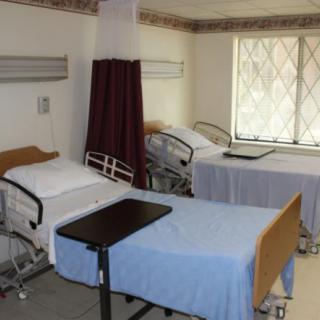 A clean and organized hospital room with two empty beds ready for patients.