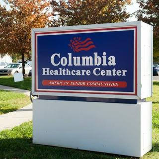 Sign for Columbia Healthcare Center with autumn trees in the background.