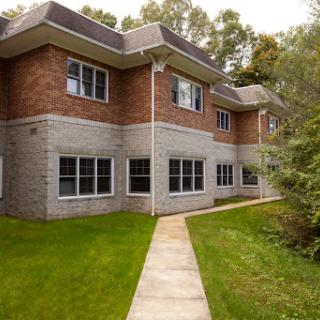 A modern residential building with a well-maintained lawn and pathway.