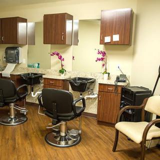 A well-organized hair salon with styling chairs, mirrors, and floral decorations.