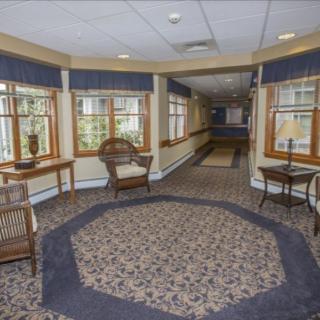 A well-decorated hallway with chairs and large windows providing natural light.