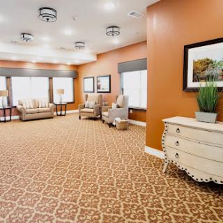 A cozy and inviting lounge area featuring comfortable seating, warm-colored walls, and decorative elements.