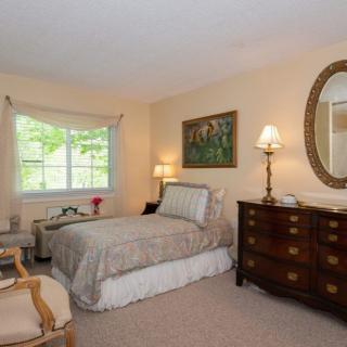 A cozy bedroom featuring a single bed, wooden furniture, and elegant decor.