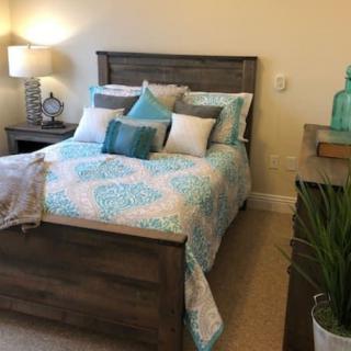 A cozy bedroom with a neatly made bed and stylish decor.