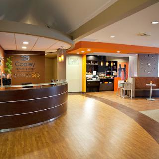 A welcoming reception area with a modern design, featuring a curved counter and a cozy seating space.