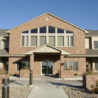 A two-story brick building with large windows and a central entrance.