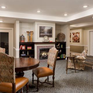 A cozy living room with a fireplace, elegant furniture, and tasteful decor.