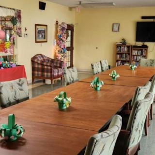A decorated meeting room with a long table, arranged chairs, and festive decorations.