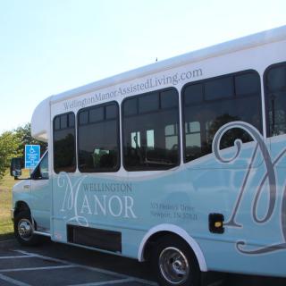 A blue shuttle bus parked in an outdoor setting.