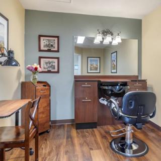 A well-organized hair salon setup with a salon chair, mirror, and wooden furnishings.