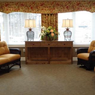 A cozy living room with two sofas, a wooden console table, and decorative lamps.