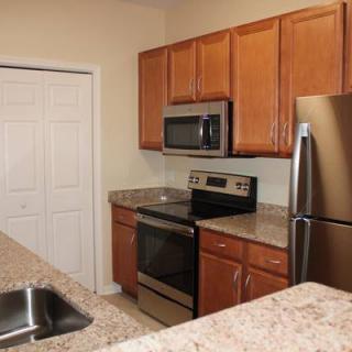 A modern kitchen featuring stainless steel appliances and wooden cabinets.