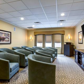 A cozy theater room with comfortable seating and a large television.