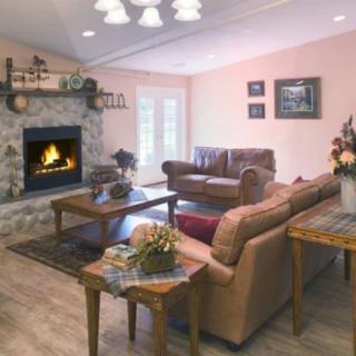 A cozy living room featuring a stone fireplace, comfortable sofas, and stylish decor.