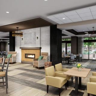 A modern hotel lobby with comfortable seating and a cozy fireplace.