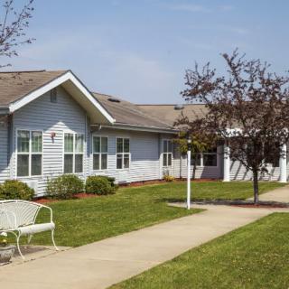 A single-story residential building with a well-maintained lawn and pathway.