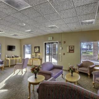 A well-lit waiting room with comfortable seating and tables.
