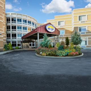 A welcoming entrance to a modern building surrounded by lush landscaping.