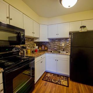 A modern kitchen with black appliances and white cabinetry.