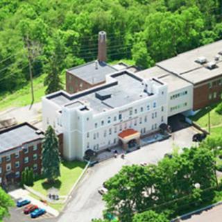 An aerial view of a building surrounded by lush greenery.
