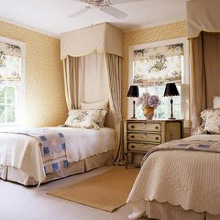 A traditional bedroom with twin beds, featuring a cream color scheme and elegant decor.