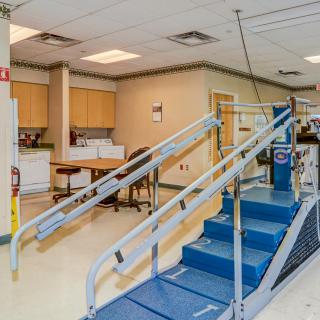 A rehabilitation clinic with therapy and exercise equipment, featuring a set of stairs for physical therapy exercises.