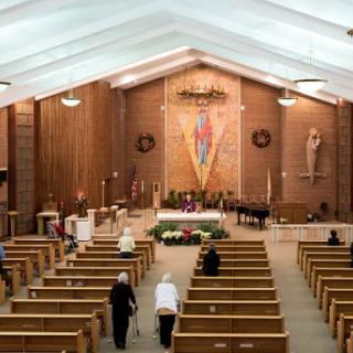A serene view of the interior of a church, highlighting the altar and wooden pews.