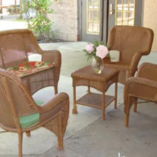 A cozy outdoor seating area with wicker chairs and a table decorated with flowers.