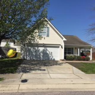 A suburban house with a driveway and garage on a sunny day.