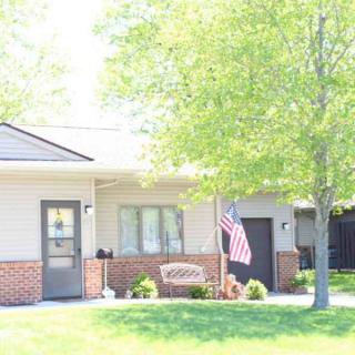 A suburban house with a front yard and an American flag displayed outside.