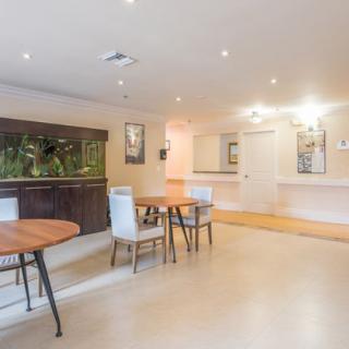 A modern dining area with wooden tables and stylish chairs, well-lit with ambient lighting.