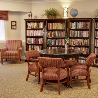 A cozy library reading area with bookshelves and comfortable seating.