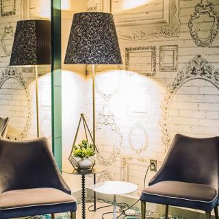 A modern interior space featuring two chairs, a decorative lamp, and artistic wall decor.