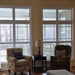 A cozy living room with two comfortable chairs by large windows letting in natural light.