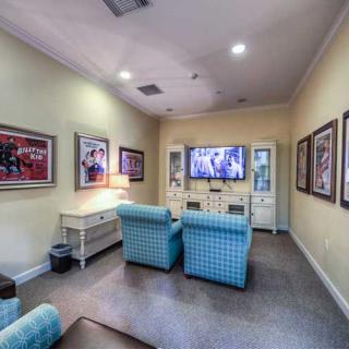 A cozy living room with comfortable seating, a large television, and framed artwork on the walls.