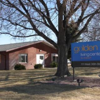 A healthcare clinic with a prominent sign and surrounding trees.