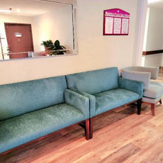 A comfortable waiting area featuring a blue sofa and armchair.