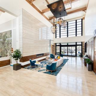 A bright and spacious modern lobby featuring stylish furniture and large windows.