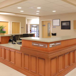 A spacious and well-lit reception area with a wooden front desk.