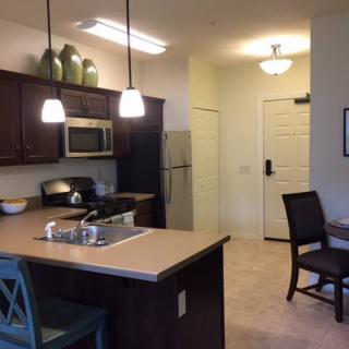 Modern kitchen with dining area featuring contemporary lighting and appliances.
