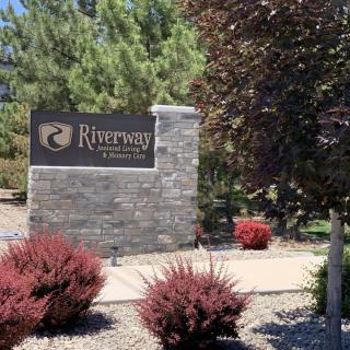 Entrance sign of Riversong community surrounded by landscaped shrubbery.