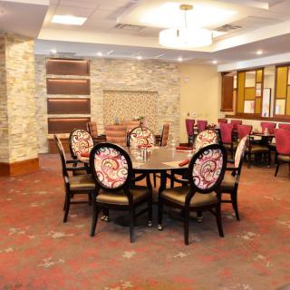 A stylish dining area with ornate chairs and a round table in an elegantly decorated room.