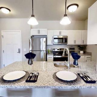 Modern kitchen with a dining setup on the countertop and stainless steel appliances.