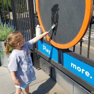 A child engaged in painting on an interactive art display.