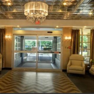 A luxurious lobby entrance with a chandelier and comfortable seating.
