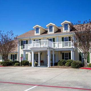 Two-story house with a balcony and driveway.