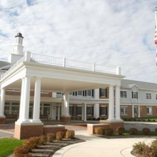 A large white building with columns and a flag in front.