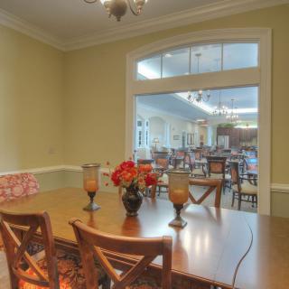 A classic dining room with a wooden table, chairs, and decorative flowers.