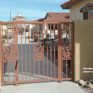 A decorative iron gate at the entrance of a residential property.