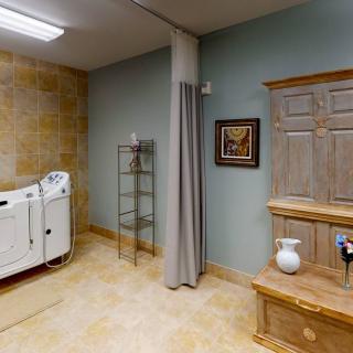 A cozy and well-decorated interior room featuring a bathtub and wooden furniture.